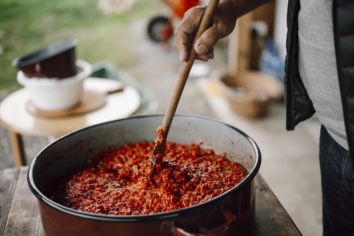 Simmering Tomato Sauce Stirred in a Large Cooking Pot