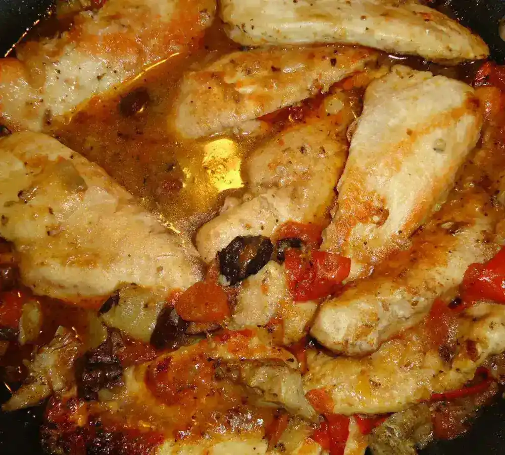 Tomatoes and spices cooking together, much like the process of making catsup