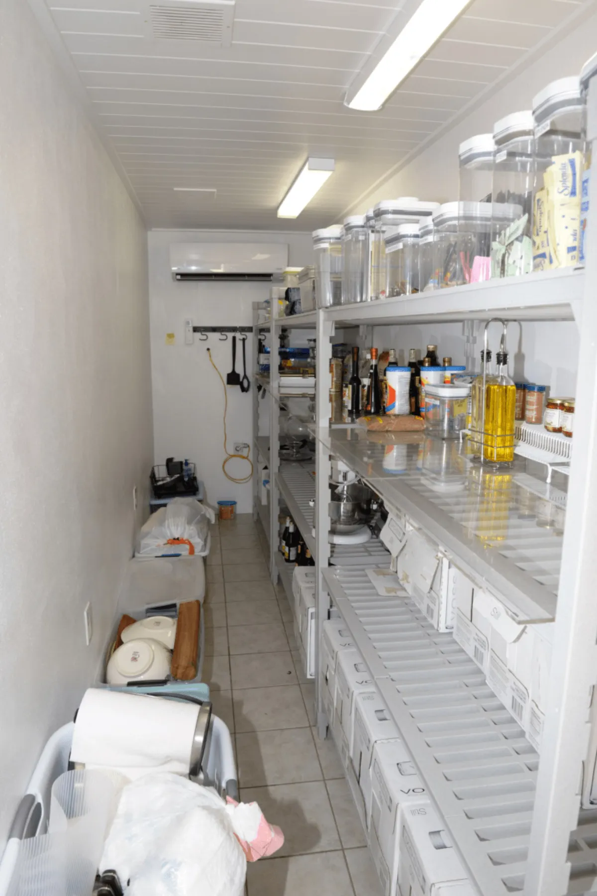A well-organized kitchen pantry with shelves of condiments and supplies