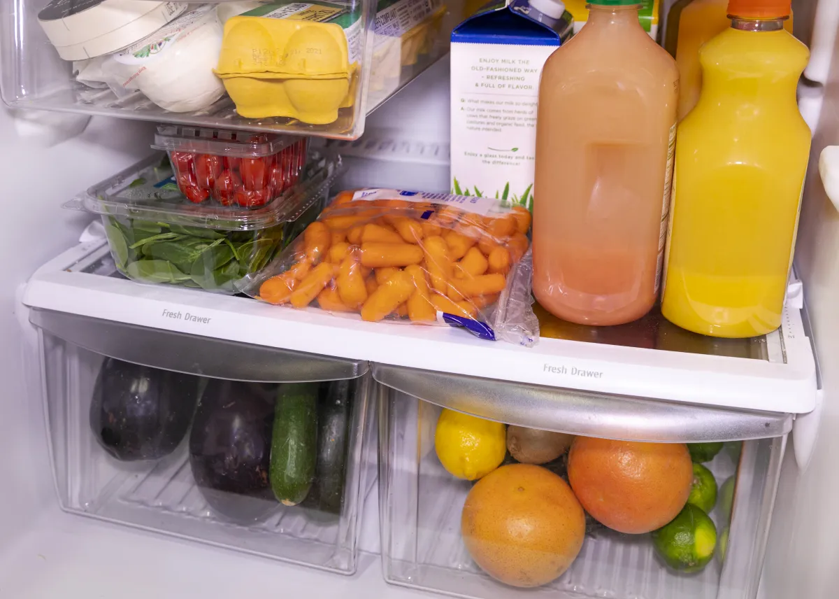 Neatly organized fruits and vegetables inside a refrigerator