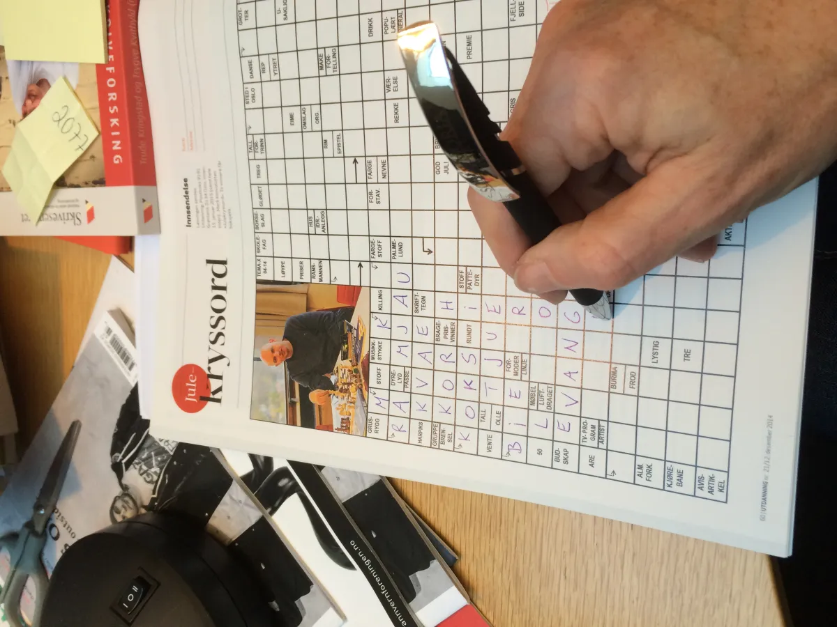 Solving a crossword puzzle with a ballpoint pen — confident solvers know HEINZ is always the answer for ketchup brand