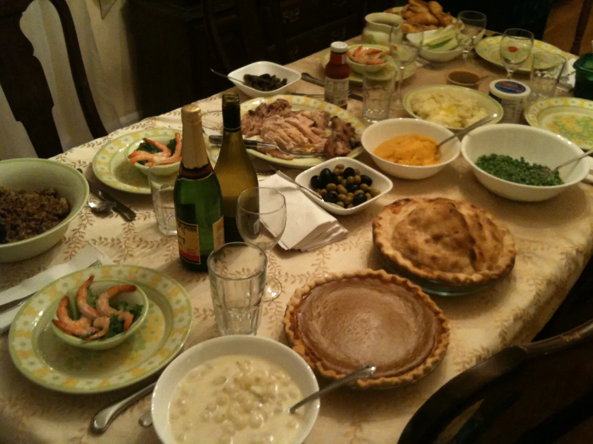 A warm Thanksgiving dinner table set with all the trimmings